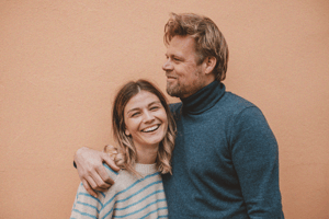 Blonde man with his arm around the shoulder of a blonde woman